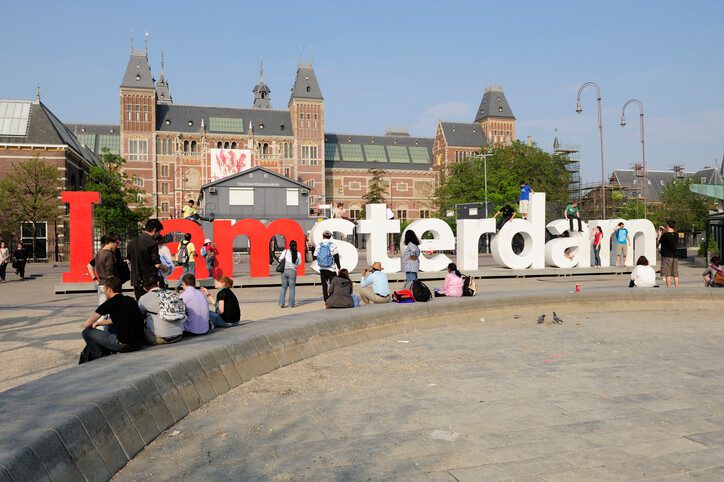 people sitting in front of the I amsterdam sign